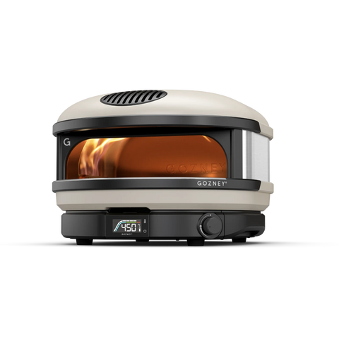 Ein moderner, kompakter Outdoor-Pizzaofen in weiß-schwarzem Design. Die Ofentür ist leicht geöffnet und lässt die Flammen im Inneren sichtbar erscheinen. Die Digitalanzeige im unteren Bereich zeigt „450“. Der Markenname „Gozney“ und sein Logo sind auf der Vorderseite sichtbar. Genießen Sie Pizza in Restaurantqualität mit diesem innovativen Gozney Arc Gas Pizzaofen.