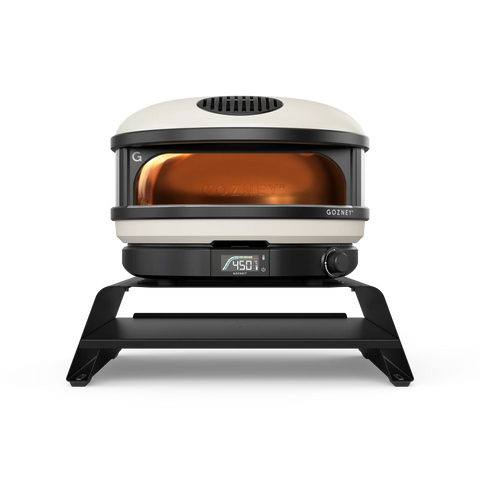 Ein moderner, eleganter Pizzaofen für die Arbeitsplatte mit einer digitalen Anzeige, die eine Temperatur von 450 °F anzeigt. Der Gozney ARC + ARC XL Booster, der in ergonomischer Höhe für Pizza-Liebhaber entworfen wurde, hat ein abgerundetes Design mit einer schwarzen Basis und einer weißen Oberseite und verfügt über ein transparentes Frontfenster, durch das das Innere und ein orangefarbenes Leuchten sichtbar sind.