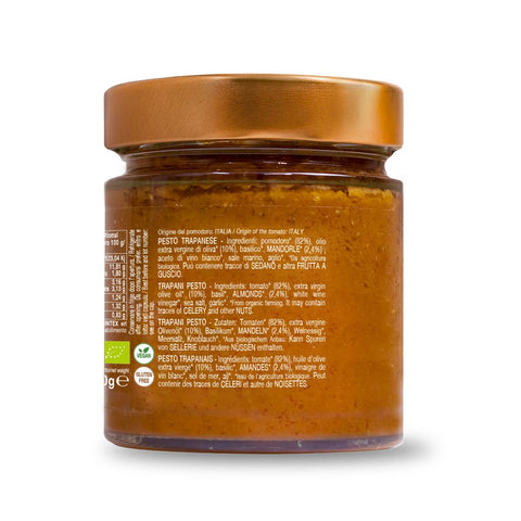 Ein Glas Bio Trapani Pesto Convivia der Marke Convivia. Das Glas hat einen goldfarbenen Metalldeckel und enthält eine rotbraune Pesto-Sauce aus getrockneten Tomaten und kalt gepresstem Olivenöl. Das Etikett enthält Zutaten und Nährwertangaben in mehreren Sprachen, das Gewicht wird mit 190 g angegeben und verschiedene Zertifizierungslogos sind sichtbar.
