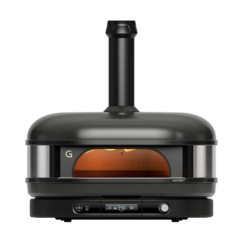Der Gozney Dome Gen 2 XL Pizzaofen - Hybrid Brennstoffsystem in schwarz verfügt über einen Schornstein, eine Glasfront, Bedienknöpfe und eine Digitalanzeige für professionelle Leistung. Der Ofen ist von innen beleuchtet und das Gozney-Logo ist auf der Vorderseite sichtbar.