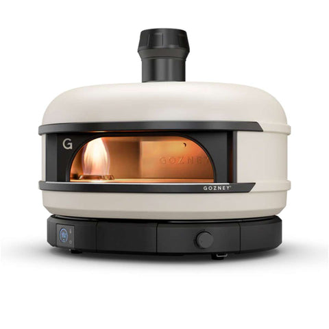 Ein weißer Gozney Dome S1 Gas-Pizzaofen steht auf einem weißen Hintergrund. Der Ofen hat einen schwarzen Sockel und eine zylindrische Form mit einem kleinen Sichtfenster, durch das man die Glut im Inneren sehen kann. Der Gozney Dome S1 Gas-Pizzaofen in Restaurantqualität zuhause verfügt über einen schwarzen Kamin und eine abgerundete Oberseite mit sichtbarem Gozney-Logo.