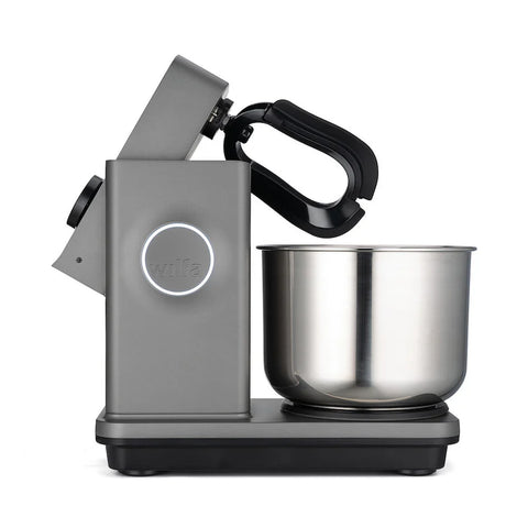 Seitenansicht der modernen grauen Wilfa Küchen- & Knetmaschine Probaker, die eine 7-Liter-Fassungsvermögen-Edelstahlschüssel und elegantes Design präsentiert. Der Mixerkopf ist nach hinten geneigt und gibt den Blick auf das doppelt effektive Knetsystem und den Befestigungspunkt für Rührwerkzeuge frei. Der Markenname „Wilfa“ ist auf der Seite sichtbar.