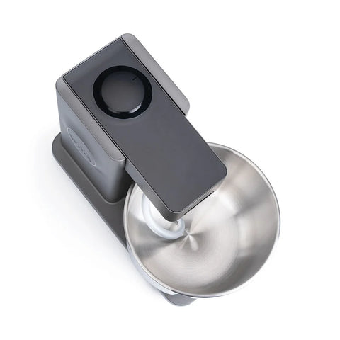 Eine stilvolle Wilfa Küchen & Knetmaschine Probaker Küchenmaschine mit einem dunklen Metallic-Finish. Sie verfügt über eine geräumige 7-Liter-Rührschüssel aus Edelstahl und zeichnet sich durch ein minimalistisches Design mit einem schwarzen Drehregler auf der Oberseite aus. Die Maschine ist von oben zu sehen, wodurch ihr doppelt effektives Knetsystem für verbesserte Leistung hervorgehoben wird.