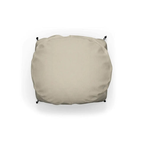 Ein beiges, quadratisches Outdoor-Kissen mit abgerundeten Kanten. Die Gozney ARC + ARC XL Abdeckhaube kurz von Gozney hat eine glatte Stoffoberfläche und schwarze Bänder an den oberen Ecken zur Befestigung an Gartenmöbeln. Der Hintergrund ist weiß und unterstreicht den neutralen Farbton des Kissens, das wetterfest ist und so zusätzlichen Schutz vor den Elementen bietet.