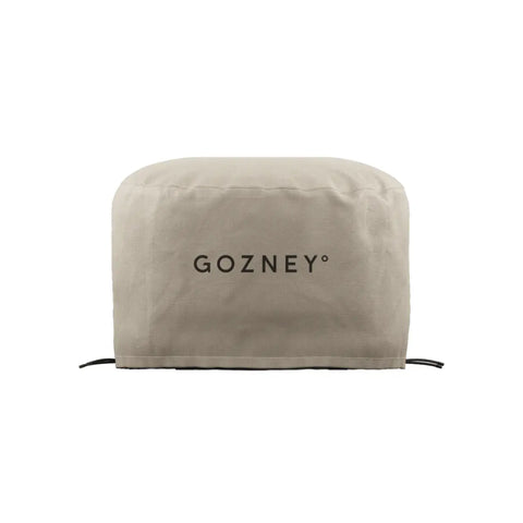 Abgebildet ist eine beige Schutzhülle mit der Aufschrift „Gozney“ in schwarzer Schrift. Die Gozney ARC + ARC XL Abdeckhaube kurz hat eine abgerundete Oberseite und schmiegt sich eng um das zu schützende Objekt. Sie bietet wetterfesten Schutz für die Elemente und verfügt an der Unterseite über verstellbare Kordeln zur Befestigung.