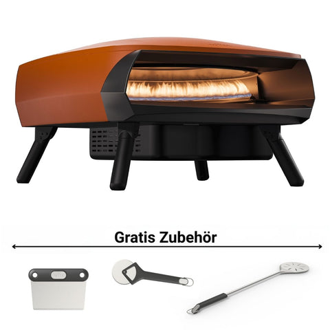 Ein stilvoller orangefarbener Witt ETNA FERMO Gas Pizzaofen von Witt wird mit einer Pizza im Inneren gezeigt, ideal für neapolitanische Pizzen. Darunter befinden sich drei kostenlose Zubehörteile: Teigschaber, Pizzaschneider und Wendeplatte. Darüber steht "Gratis Zubehör".