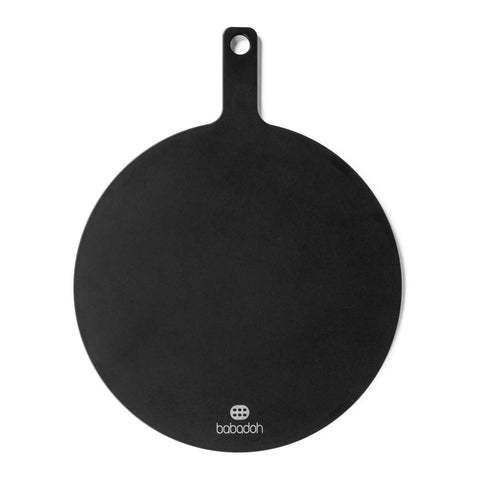 Wir präsentieren das Babadoh Pizza-Servierbrett 2er-Set, ein schwarzes rundes Schneidebrett mit Griff und praktischem Loch zum Aufhängen. Der Griff erstreckt sich von der Oberseite des runden Bretts und in der Mitte unten ist die Marke „Babadoh“ aufgedruckt. Dieses Schneidebrett aus Holzfaserbrettern ist perfekt, um Ihre Pizzakreationen zu präsentieren und bietet eine umweltfreundliche Option.