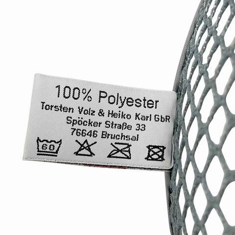 Nahaufnahme eines Stoffetiketts auf einem Netzmaterial für das Teiger Teigreinigungstuch (Doppelpack) von Pizzalovers. Auf dem Etikett steht „100 % Polyester“ und die Kontaktdaten der Torsten Volz & Heiko Karl GbR mit Sitz in der Spöcker Straße 33, 76646 Bruchsal. Als ideales Reinigungstuch für die Küche konzipiert, enthält es Wäschesymbole für Waschanweisungen.