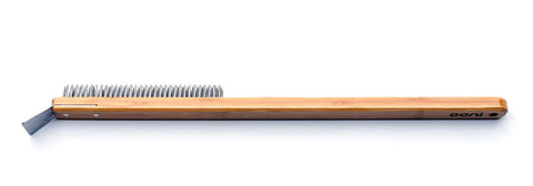 Une brosse de nettoyage avec un long manche, un corps en bois et des poils métalliques, à l'une des extrémités desquels est fixé un grattoir en acier inoxydable. Le mot "Brosse pour four à pizza Ooni" est imprimé sur le manche, près de la tête de la brosse. Cette brosse pour four à pizza Ooni est conçue pour nettoyer les barbecues ou les fours à pizza.