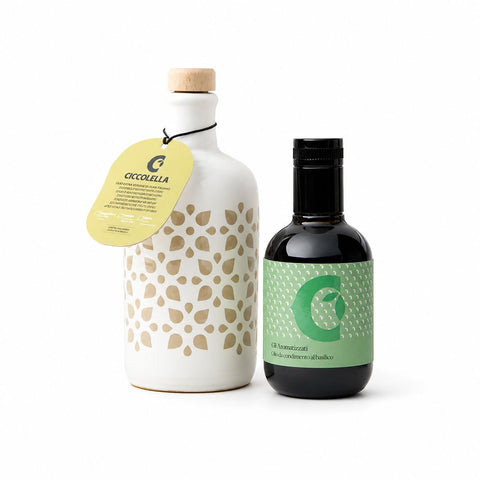Zwei Flaschen nebeneinander: eine weiße Keramikflasche mit einem Holzverschluss und einem beigen Blattmuster sowie eine dunkle Flasche mit einem grünen Etikett, auf dem ein ähnliches Blattmuster und der Buchstabe „C“ zu sehen sind.