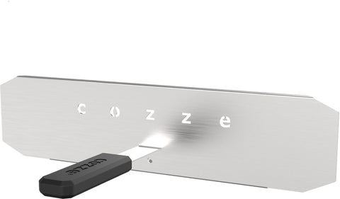Das Cozze Hitzeschild für 17 inch Pizzaofen aus Edelstahl besitzt einen "cozze" Ausschnitt in der Mitte und einen schwarzen Griff unten links.