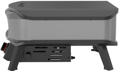 Der Cozze 17 Zoll Pizzaofen PREMIUM ROTATE, Gas 50mbar - CH-Regler ist ein tragbarer schwarz-silberner Tisch-Gasgrill mit stabilen Beinen, seitlichen Lüftungsöffnungen und einem Bedienknopf vorne links - perfekt für neapolitanische Pizza.