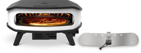 Ein moderner Cozze 17 Zoll Pizzaofen, Gas 50mbar mit rotierendem Pizzastein (CH-Regler) backt eine Pizza bei sichtbaren Flammen. Daneben liegt ein abnehmbares Metall-Frontpanel mit "cozze"-Schriftzug und Griff für perfekte Ergebnisse.