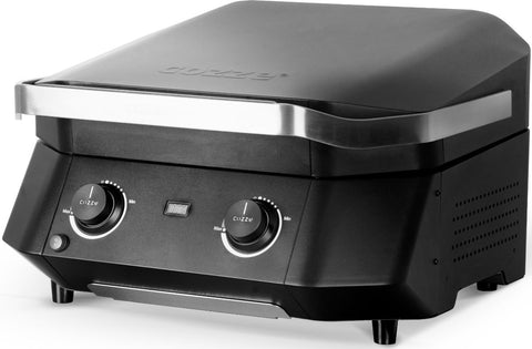 Der schwarze Cozze E-500 Grill, elektrisch 230V (CH-Stecker), verfügt über eine Metallverkleidung, zwei Bedienknöpfe, eine Digitalanzeige und einen geschlossenen Deckel - perfekt für die Zubereitung von Speisen im Innen- oder Außenbereich. Genieße Grillen ohne Gas und Kohle mit Cozze!.