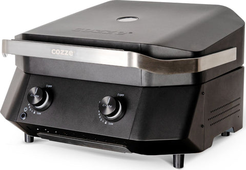 Der Cozze G-500 Plancha mit Deckel, Gas 50mbar - CH-Regler von Cozze ist ein schwarzer Tisch-Gasgrill mit geschlossenem Deckel, zwei Bedienknöpfen, Edelstahlgriff und Gusseisen-Grillplatte.