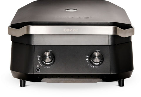 Die Cozze G-500 Plancha mit Deckel, Gas 50mbar - CH-Regler ist ein eleganter, schwarzer Arbeitsplattenofen mit zwei Bedienknöpfen ("High" und "Low"), Edelstahlverkleidung und einer Gusseisen-Grillplatte für authentisches Grillen.