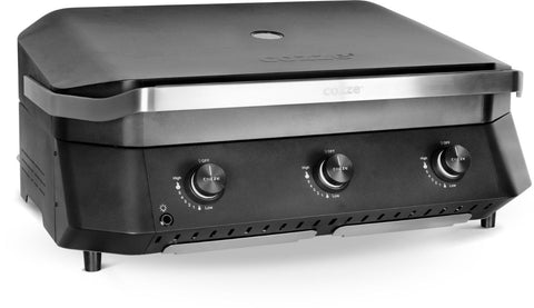 Die Cozze G-800 Plancha mit Deckel von Cozze ist ein schwarzer, kompakter Gasgrill mit drei Frontknöpfen, einem gewölbten Deckel mit Edelstahlgriff und vier Beinen - perfekt für Ihre Outdoor-Küche. Modernes Design, Gusseisen-Grill, Gas 50mbar - CH-Regler inklusive.