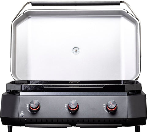 Der Cozze G-800 Plancha mit Deckel, Gas 50mbar - CH-Regler von Cozze ist ein eleganter schwarz-silberner Outdoor-Gasgrill mit drei roten Knöpfen und einem offenen Deckel - ideal für Ihre Outdoor-Küche oder in Kombination mit Gusseisen-Grill-Zubehör.