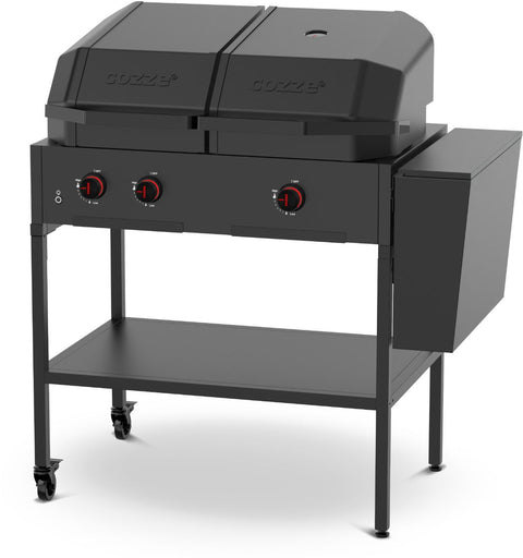 Der Cozze Elements Abfalleimer von Cozze ist ein schwarzer Zwei-Flammen-Gasgrill für den Außenbereich auf vier Beinen (zwei davon mit Rädern), mit Outdoor-Küchen-Modul, zwei abgedeckten Fächern, vorderen Bedienknöpfen, seitlichem Ablagefach und unterer Ablage.