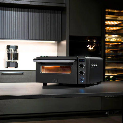 Der KYS Vero 500 Pro Elektro Pizzaofen von KYS, ein moderner schwarzer Pizzaofen mit digitaler Steuerung, ist ideal zum Backen neapolitanischer Pizza zu Hause und passt perfekt in Küchen mit dunklen Schränken und Einbaugeräten.