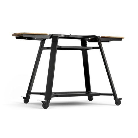 Der Gozney Stand & Pizzaofentisch für Dome 2.0 und Dome 2.0 XL von Gozney ist ein eleganter schwarzer Metallwagen mit vier Rädern, abgewinkelten Beinen, unterer Ablage und hölzernen Seitenverlängerungen - das ideale moderne Pizzaofen-Zubehör für Ihren Dome Gen 2.