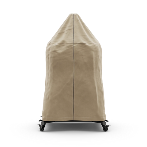Eine hohe, beigefarbene Gozney Abdeckhaube für Dome 2.0 / Dome 2.0 XL Lang mit sichtbaren Nähten bedeckt einen Terrassenheizer auf schwarzen Lenkrollen vor einem schlichten weißen Hintergrund. Marke: Gozney.