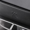 Nahaufnahme der schwarzen Metalloberfläche der KernKraft KnetKraft 5 Spiral-Knetmaschine mit geprägtem "K"-Logo und einem glänzenden, gebogenen Drahtgestell - Markenzeichen dieser hochwertigen Knetmaschine für perfekten Pizzateig. Der Deckel ist glatt und stabil.