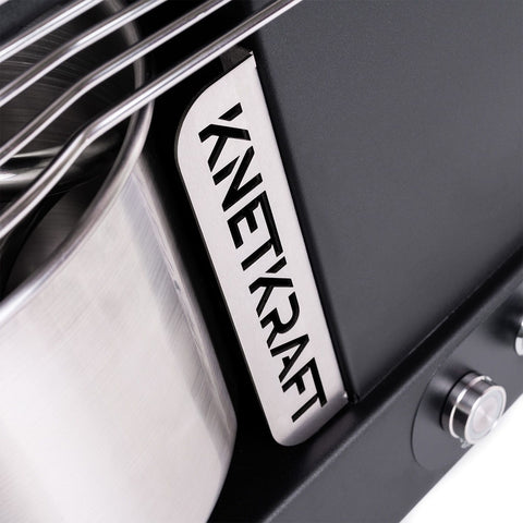 Nahaufnahme der KernKraft KnetKraft 5 Spiral-Knetmaschine mit Metallic-Design und "KNETKRAFT"-Ausschnittplatte. Inklusive teilweiser Rührschüssel aus Edelstahl - perfekt für die Zubereitung von Pizzateig und mehr.