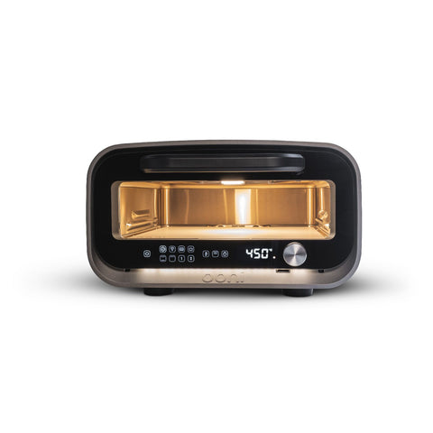 Das Ooni Volt 2 Elektro Pizzaofen & Halo Pro Spiral-Knetmaschine Bundle von Ooni ist ein kompakter, moderner Pizzaofen mit Glastür, beleuchtetem Innenraum, digitaler Anzeige bei 450°F, Bedienknöpfen und einem silbernen Drehknopf auf weißem Grund.