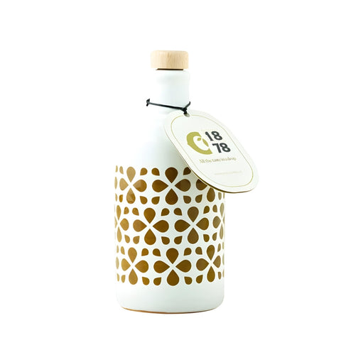 Ein ORCIO Keramik Intensità Olivenöl extra vergine (250 ml) von Ciccolella wird in einer weißen Keramikflasche präsentiert, die mit einem Holzverschluss und einer schwarzen Schnur, die das Etikett sichert, verziert ist. Die Flasche weist ein elegantes goldenes Blumenmuster auf und trägt ein rundes Etikett mit der Aufschrift „C18 78“ und zusätzlichem Text. Es eignet sich perfekt zur Aufbewahrung von Olivenöl extra vergine und steht anmutig vor einem schlichten weißen Hintergrund.
