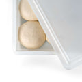 Ein teilweise geöffneter weißer Deckel gibt den Blick auf drei runde Teigbällchen frei, die nebeneinander in einem Fumosa FUMOSA Pizzaballen-Box-Set (40x30x7) liegen. Der glatte, helle Teig bildet einen Kontrast zum Behälter und unterstreicht das frühe Stadium der Brot- oder Pizzazubereitung.